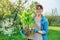 Beautiful middle aged woman with rooted hosta plant looking at camera