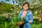 Beautiful middle aged woman with rooted Periwinkle plant looking at camera