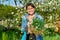 Beautiful middle aged woman with rooted Periwinkle plant looking at camera