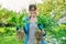 Beautiful middle aged woman with rooted plants looking at camera