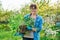 Beautiful middle aged woman with rooted sedum plant looking at camera