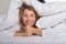 Beautiful middle-aged woman under white sheets