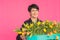 Beautiful middle-aged woman with yellow tulips on pink background. Floristics, holidays and gifts concept