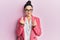 Beautiful middle eastern woman wearing business jacket and glasses doing money gesture with hands, asking for salary payment,