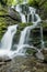 Beautiful milky and high waterfall in the forest. The waterfall is surrounded by forest