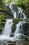 Beautiful milky and high waterfall in the forest. The waterfall is surrounded by forest