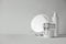 Beautiful minimalist conceptual all white composition - transparent jar and plastic bottle with pump, round mirror