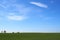 Beautiful minimalist spring landscape plain with green meadows blue sky with white clouds