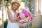 Beautiful mixed flower bouquet hold by smiling woman