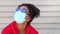 Beautiful mixed race African American girl biracial teenager young woman outside wearing a face mask and sunglasses