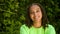 Beautiful mixed race African American girl teenager young woman laughing and happy wearing a green t-shirt outside