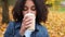 Beautiful mixed race African American girl teenager young woman wearing a blue denim jacket outside sad then happy drinking coffee