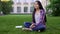 Beautiful mixed-race girl sitting on lawn near college and dreaming about date
