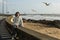 Beautiful mixed -race woman sits on the waterfront during the surf and gulls around.