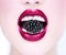 Beautiful model girl eating blackberry, closeup. Beauty young fashion woman lips with fresh organic black berry