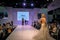 Beautiful model posing catwalk on stage showing wedding and bridal dresses