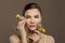 Beautiful model woman with clear skin and flowers on brown background. Herbal medicine and skincare concept