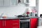 Beautiful modern clean red kitchen in small apartment full shot