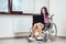 Beautiful modern disabled girl working on a laptop in a wheelchair. Work from home, work for the disabled, freelancing, remote