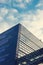 A beautiful, modern, mirrored building. The view from below. Sky with clouds. Corporate building.