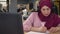 Beautiful modern muslim business woman uses a microphone and headphones in office. Friendly and smiling online Video