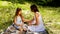 Beautiful mom and daughter playing a game of rock, paper, scissors in the park