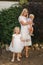 Beautiful mom with son and daughter walkink in the park. Blonde hair family. Little children