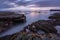 A beautiful moody seascape with misty waves and rocks in the foreground