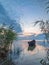 Beautiful morning landscape with a boat on the lake at the sunrise through the reed