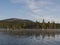 Beautiful morning over lake Sjabatjakjaure with view on Parte Fjallstuga STF mountain cabin, green hills and birch trees. Sweden