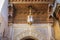 Beautiful Moroccan art in the city of Fez. Wooden carved ceiling, antique lamp and arabesque art on the wall. Morocco.