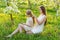 Beautiful mother and daughter in a blooming garden in the spring