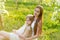 Beautiful mother and daughter in a blooming garden in the spring