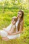 Beautiful mother and daughter in a blooming garden in the spring