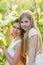 Beautiful mother and daughter in a blooming garden in the spring