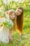 Beautiful mother and daughter in a blooming garden in the spring