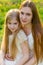 Beautiful mother and daughter in a blooming garden in the spring