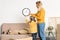 beautiful mother and daughter hanging clock on wall during relocation