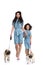 beautiful mother and daughter in similar dresses walking with pugs