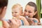 Beautiful mother helping her son to brush teeth in bathroom