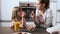 Beautiful mother and her daughter taking and eating cereals of bowl in the kitchen at home