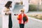 A beautiful mother with her son in a bright orange jacket and a fashionable yellow hat are walking from the store