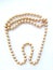 Beautiful mother-of-pearl round light beige large beads on a tooth-shaped thread isolated object on a white background