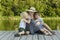 Beautiful mother with two young sons are embracing on the pier on the river bank