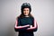 Beautiful motorcyclist woman with curly hair wearing moto helmet over white background happy face smiling with crossed arms