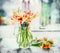 Beautiful mottled tulips bunch in glass vase at window with spring nature. Parrot tulips
