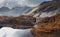 beautiful Mountain fall landscape with a lake, the sun illuminates a rock wet after rain