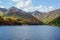 Beautiful mountain lake in the valley of the hills, in autumn, among thousands of colorful trees