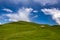 Beautiful mountain landscape at Caucasus mountains with clouds, blue sky and line of horse riders far away