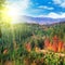 Beautiful mountain landscape with colorful autumnal forests and vibrant sunset